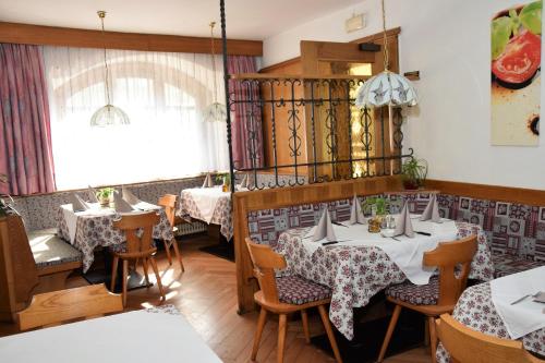 a restaurant with tables and chairs and a window at Sterzingerhof in Vipiteno