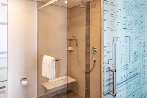 a bathroom with a shower with a glass door at City Lodge Hotel at OR Tambo International Airport in Kempton Park