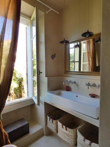 une salle de bain avec un lavabo, un miroir et une fenêtre dans l'établissement The French Village Authentic House, à Cogolin
