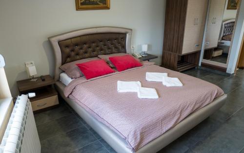 a bed room with a white bedspread and pillows at Hotel Bella Nella in Leskovac
