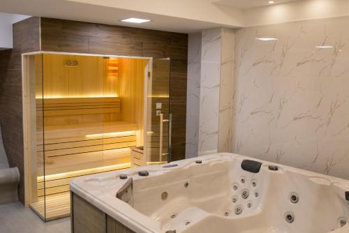 y baño grande con bañera y ducha. en Hotel Bella Nella, en Leskovac