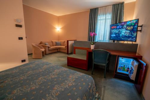 a hotel room with a bed and a flat screen tv at Hotel Diana in Valdobbiadene