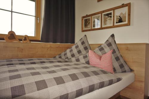a bedroom with a bed and two pillows at Apartment Alpenstyle by Katharina in Zell am Ziller