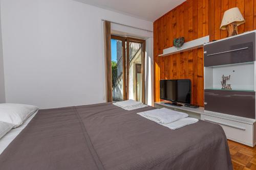 a bedroom with a large bed and a tv at Apartmani Pilaš in Dramalj