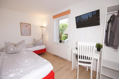 um quarto com uma cama, uma secretária e uma janela em Ferienhaus II Wiesenblick em Grömitz
