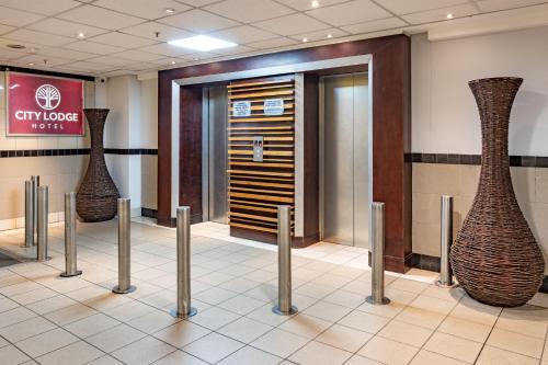 a lobby with two vases on the wall at City Lodge Hotel at OR Tambo International Airport in Kempton Park