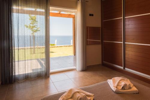 La salle de bains est pourvue d'une douche et d'une porte coulissante en verre. dans l'établissement Blue Horizon Villas with Private Pool & Sea View, à Plateies