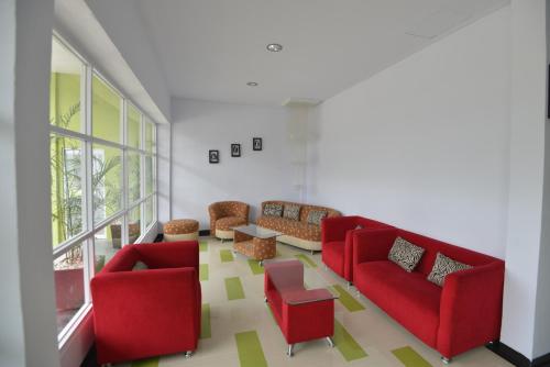 uma sala de estar com sofás vermelhos e uma mesa em T-ONE HOTEL em Tanjungjohor