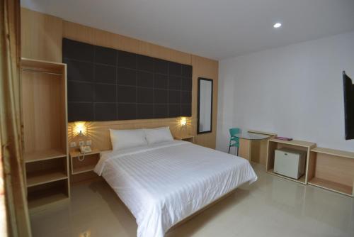 1 dormitorio con cama blanca y pared negra en T-ONE HOTEL en Tanjungjohor