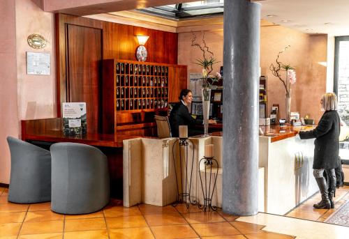 a man and woman standing at a bar in a restaurant at Hotel Diana in Valdobbiadene