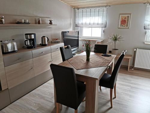 uma cozinha com uma mesa de jantar com cadeiras em Privatzimmer Guhl em Munster im Heidekreis