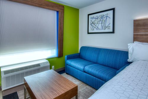 a living room with a couch and a bed at Holiday Inn Express & Suites Omaha Downtown Old Market by IHG in Omaha