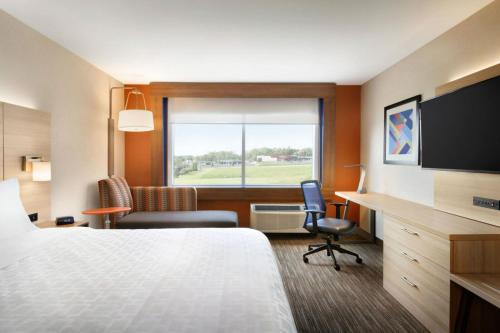 a hotel room with a bed and a desk and a window at Holiday Inn Express & Suites Omaha Downtown Old Market by IHG in Omaha
