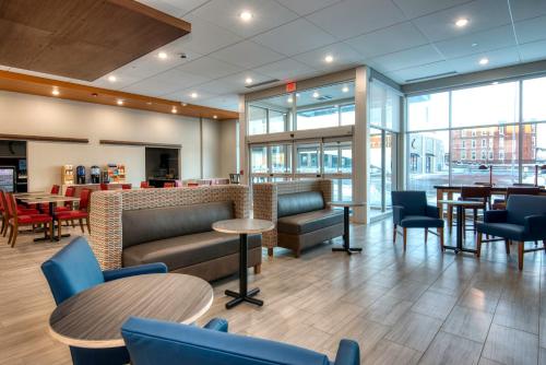 a lobby with tables and chairs and a restaurant at Holiday Inn Express & Suites Omaha Downtown Old Market by IHG in Omaha