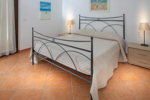 a bedroom with a bed and a tiled floor at Il Mare di Alida in Alghero