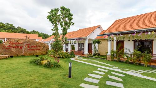 a house with a garden and a large rock at Bungalow Sáng Tươi Mountains in Phu Quoc