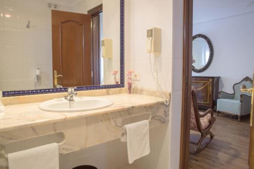 La salle de bains est pourvue d'un lavabo et d'un miroir. dans l'établissement Hotel Museo Los Infantes, à Santillana del Mar