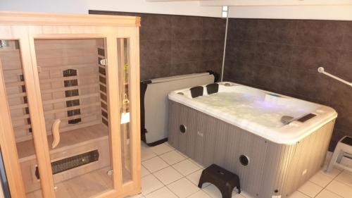 a bathroom with a bath tub and a toilet at B&B Manoir de la Fabrègues in Estaing