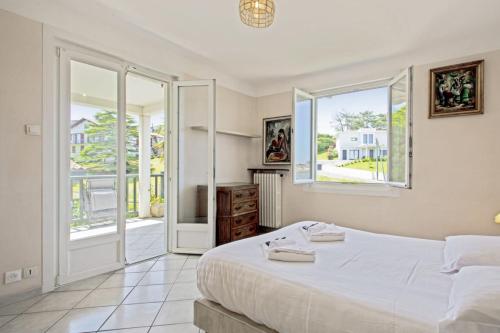 une chambre avec un grand lit et deux fenêtres dans l'établissement Appartement des Basques - Welkeys, à Ciboure