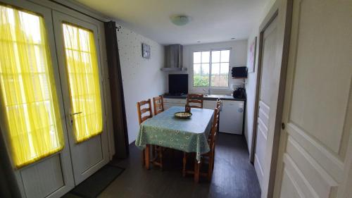 a small kitchen with a table and chairs in a room at Villa JULIENNE - Chalet de charme - la plaine des cafres in La Plaine des Cafres