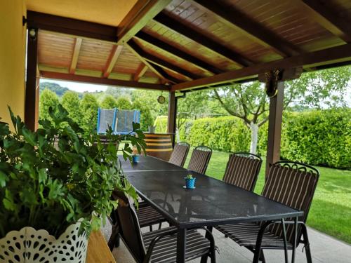 a black table and chairs under a wooden pergola at Vila Ema in Krapinske Toplice