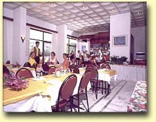 a group of people sitting at tables in a restaurant at Dias Hotel in Kusadası