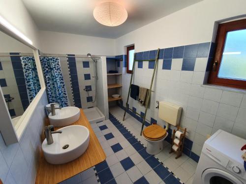 baño azul y blanco con lavabo y aseo en Relax in the countryside near the sea en Bonini