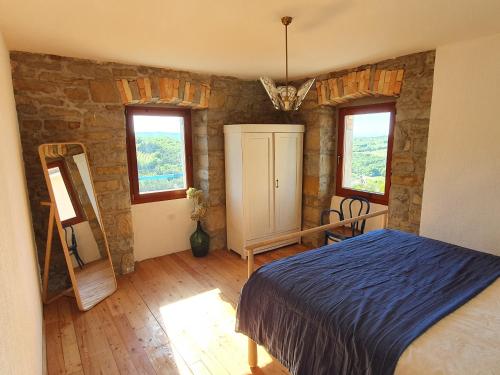 Schlafzimmer mit einem Bett, einem Spiegel und Fenstern in der Unterkunft Relax in the countryside near the sea in Bonini