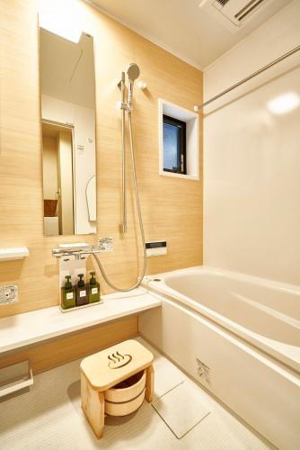 a bathroom with a tub and a toilet and a sink at Kitano Tenmangu The House in Kyoto
