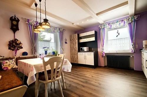 a room with a table and a kitchen with purple walls at Haus Lila Welle in Nordhalben