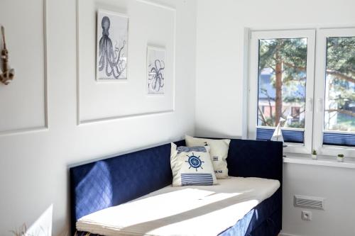 niebieska ławka w pokoju z oknem w obiekcie APARTAMENT 19B BLUE MARINE Poddąbie Basen Odkryty Brodziki Plac Zabaw w Poddąbiu
