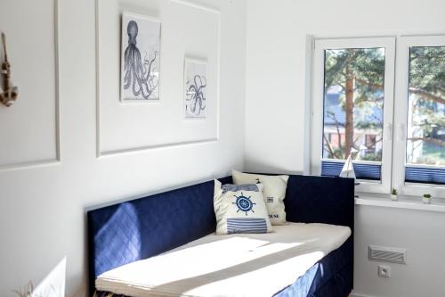 a blue bench in a room with a window at Apartament 19B Blue Marine Poddąbie in Poddąbie