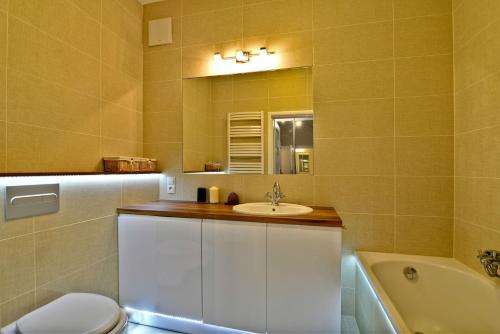 W łazience znajduje się umywalka, toaleta i lustro. w obiekcie 14-nastka Nowe Orłowo Gdynia w mieście Gdynia