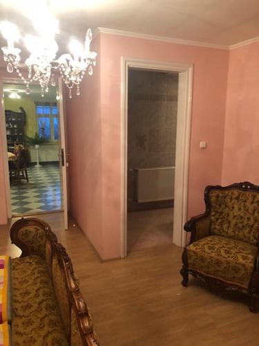 a living room with a chair and a chandelier at Aranycsillag Apartman in Balatonfüred