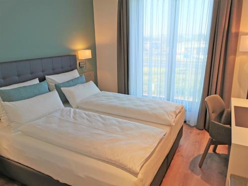 a bedroom with a large bed with a large window at Zeitlos Boutiquehotel in Limburg an der Lahn