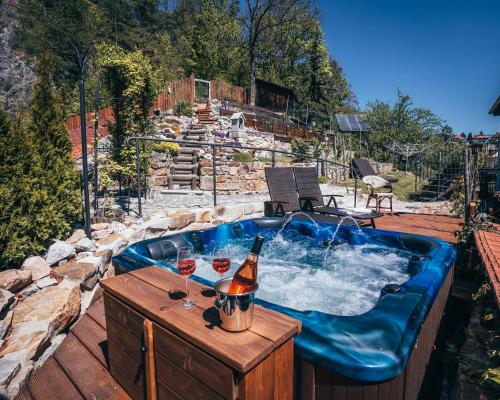 a hot tub with a bottle of wine and two glasses at Pension Fialka in Český Krumlov