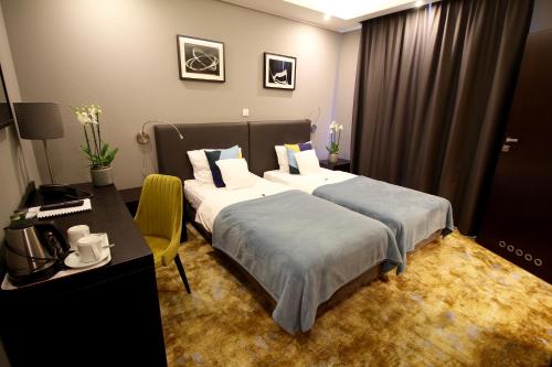 a hotel room with two beds and a desk at Malta Premium in Poznań