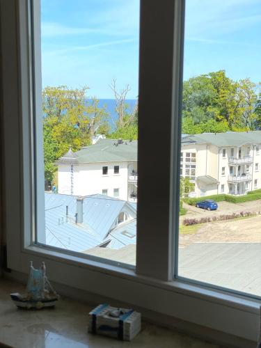 an open window with a view of a building at Meerblick Apartment in Göhren