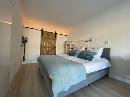1 dormitorio con 1 cama grande y suelo de madera en Casa del Mar Zandvoort, en Zandvoort