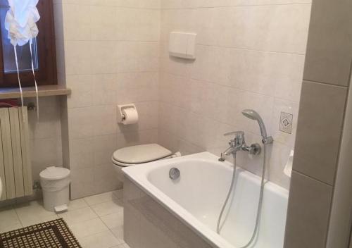 a bathroom with a bath tub and a toilet at Appartamento Sofia in Lazise