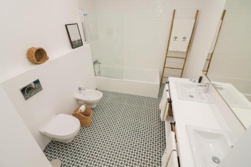 a white bathroom with a toilet and a sink at Monte das Mós in Ourique