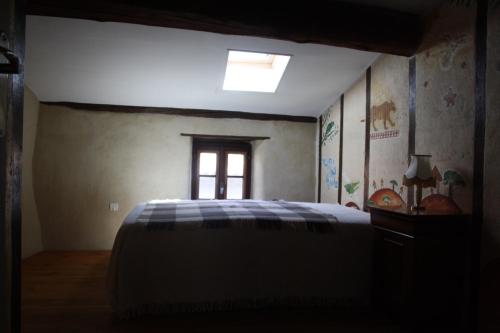 Schlafzimmer mit einem Bett und einem Fenster in der Unterkunft Montségur ARIEGE grande maison éco-rénovée in Montségur