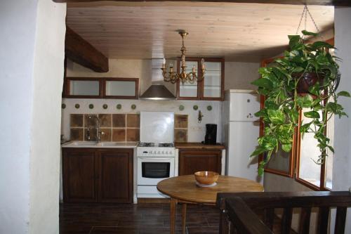 uma cozinha com uma mesa e um frigorífico branco em Montségur ARIEGE grande maison éco-rénovée em Montségur