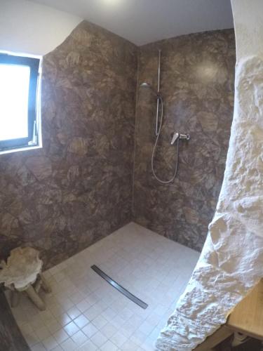 a bathroom with a shower with a stone wall at Zum Alten Pfarrhaus in Damscheid
