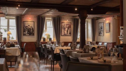 Les Chambres de Louise في Habsheim: مطعم فيه طاولات وكراسي في الغرفة