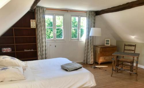 - une chambre avec un lit, une chaise et une fenêtre dans l'établissement Gite de Mauxe, à Acquigny