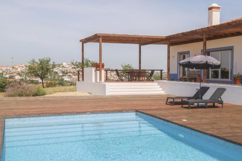 a house with a swimming pool in front of a house at Monte das Mós in Ourique