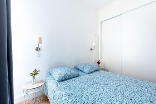 - une chambre blanche avec un lit bleu et une table dans l'établissement 1 CASSINI - Magnifique 2 pièces place Garibaldi - Balcon, à Nice