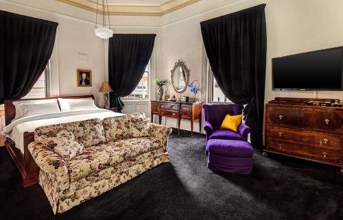 a bedroom with a bed and a couch and a tv at Langsford Luxury in Stawell