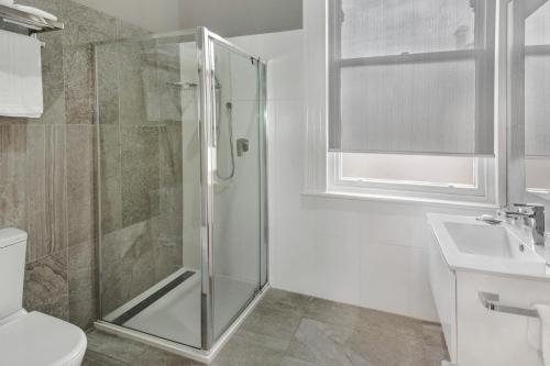 a bathroom with a shower and a toilet and a sink at Langsford Luxury in Stawell